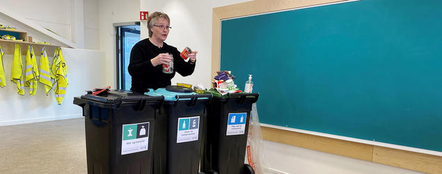 Kirsten forklarer hvordan avfall skal sorteres i ulike dunker. Foto. 