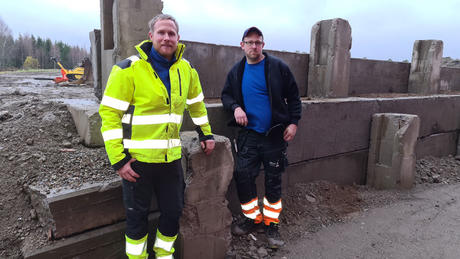 Espen (t.v) og Steffen står foran muren de har vært med på å bygge. Foto. 