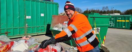 Henry Dahl Johansen står over en konteiner med plastemballasje. Foto. 