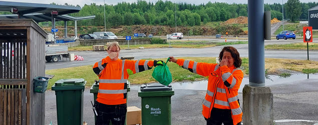 To ØRAS-ansatte holder en illeluktende matavfallspose. Foto. 
