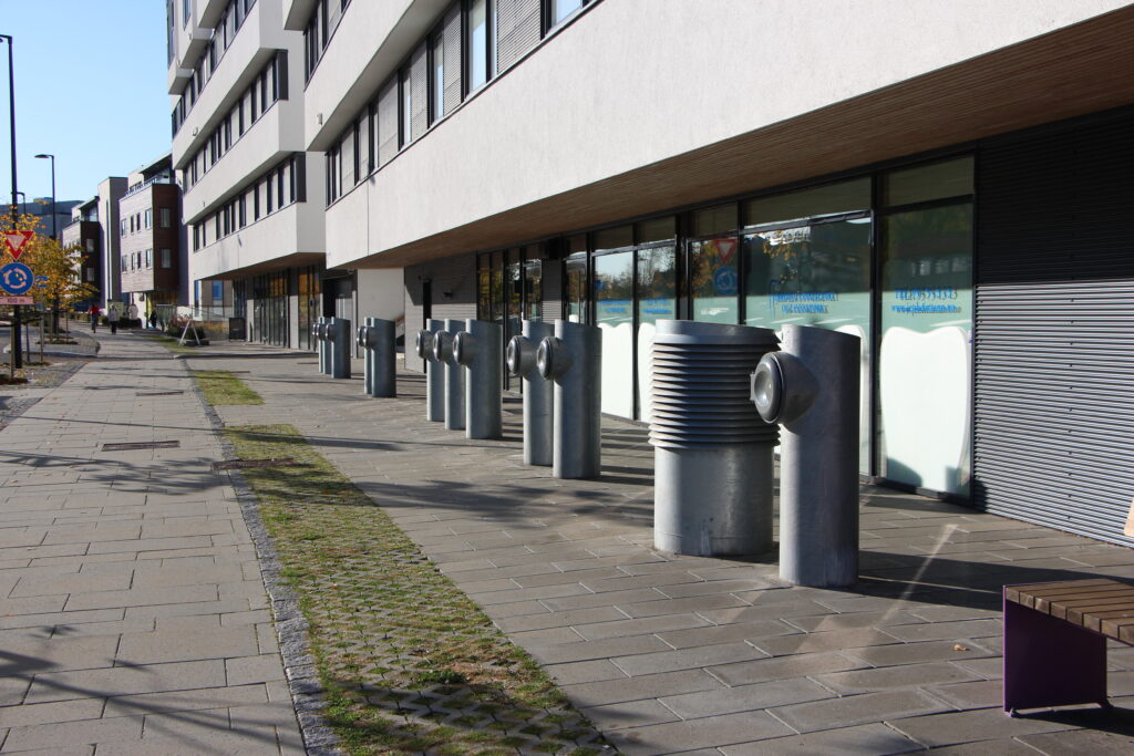 Gate ved leilighetskompleks som ha avfallssugbeholdere