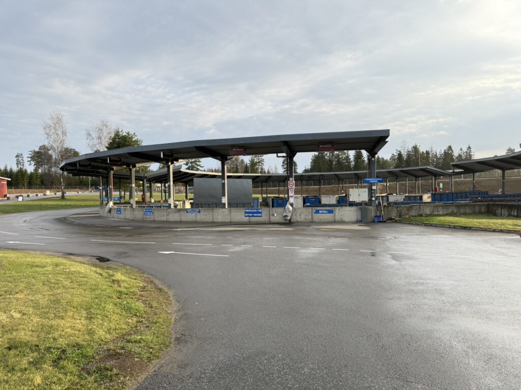 Gjenvinningsstasjon utformet som en sirkel med konteinere under tak